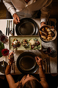 A couple enjoy a meal at the food-sharing table at the Hotel Winzer