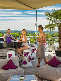Guests enjoy cocktails at the Skybar on the sun deck at the Wellnesshotel Winzer