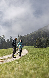 A couple are walking along the Sweet Chestnut Trail by Lake Attersee in the Salzkammergut