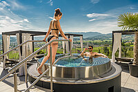 A couple enjoying the hot tub on the sun deck at the Hotel Winzer