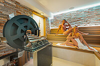 A couple in the waterwheel sauna at the Sole Spa in the Hotel Winzer