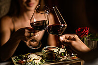 A woman with a glass of wine at the food-sharing table at the Adults Only Hotel Winzer